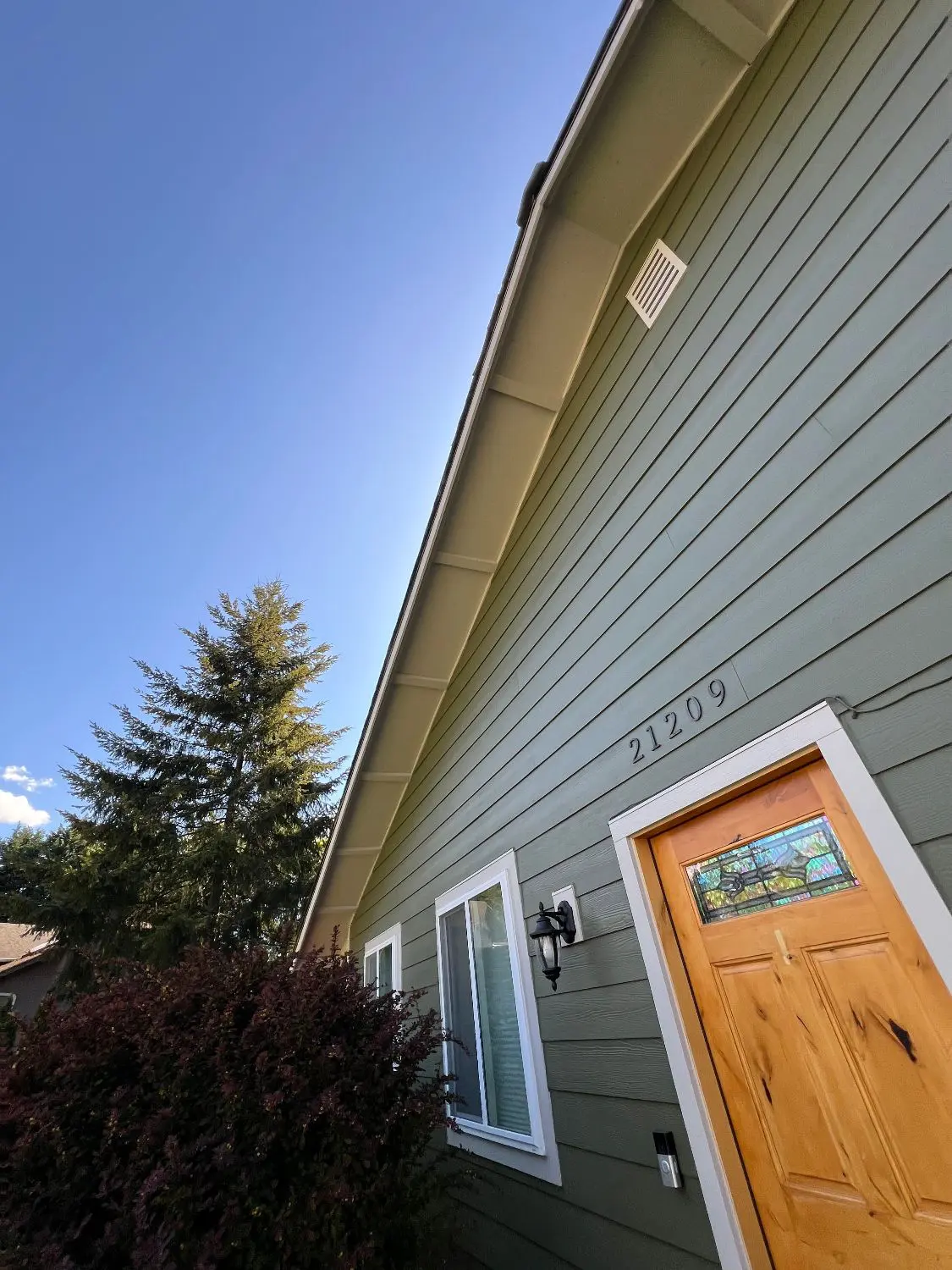 Freshly painted downspout and meter conduit matched to new siding color